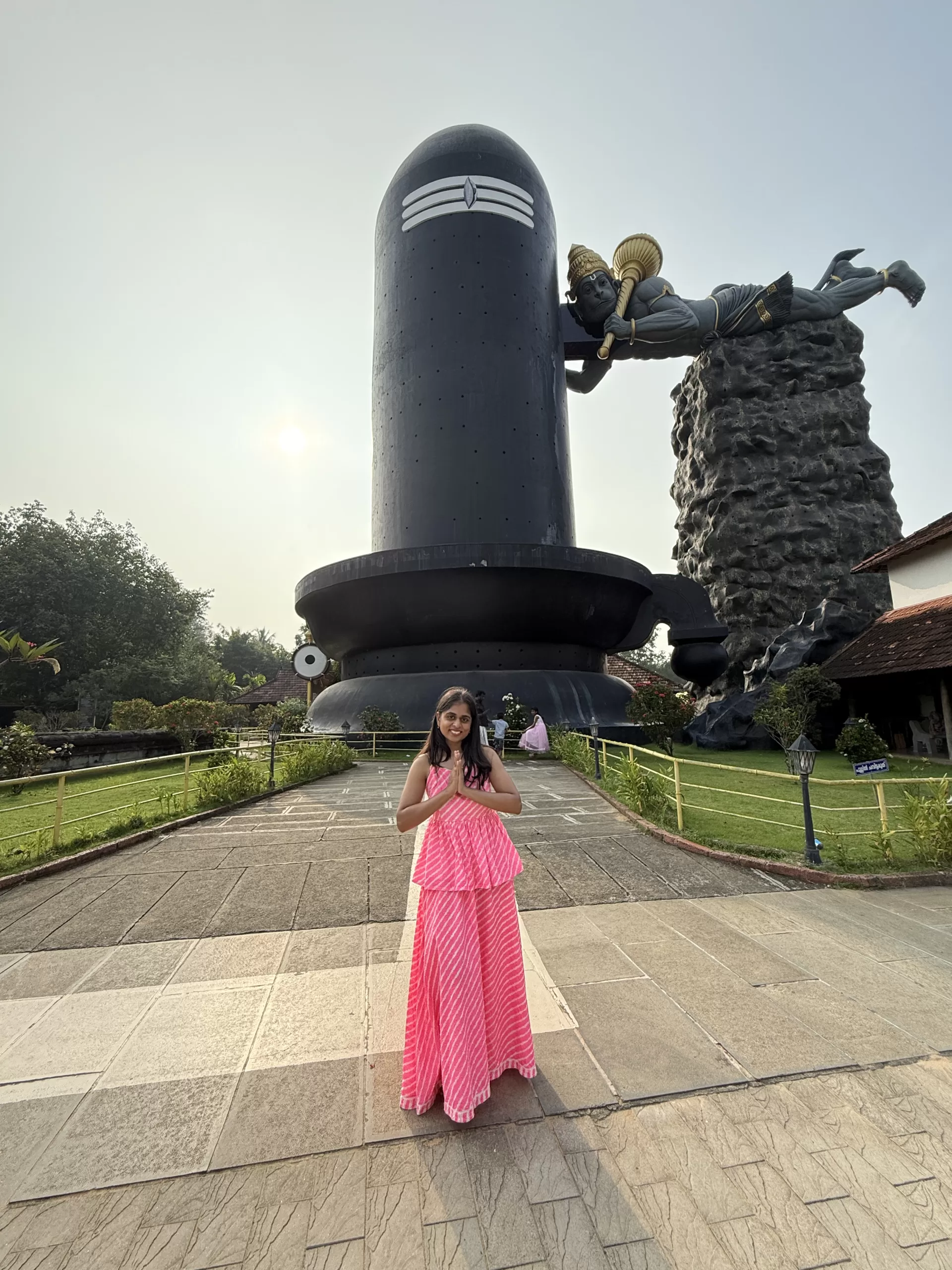 Visitor posing in front of world tallest Shiva Lingam in Kerala