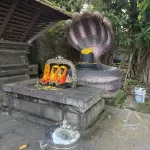 Shiva lingam under multi-hooded serpent sculpture in Kerala temple