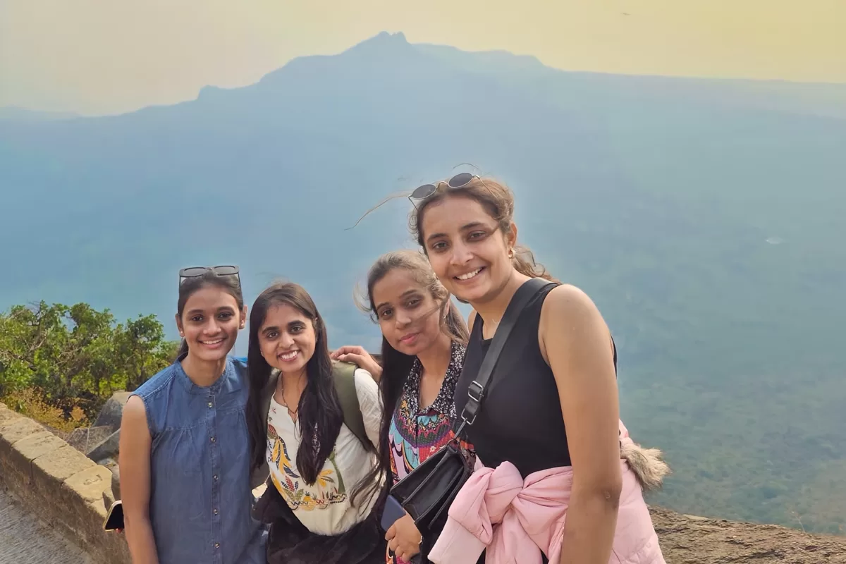 Four women travelers enjoying a spiritual trip to Junagadh with Girnar Hills in the background