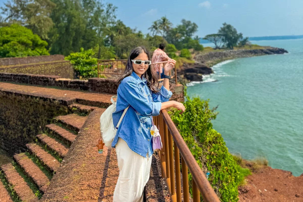 Travel blogger standing at St. Angelo Fort in Kannur Kerala overlooking Arabian Sea coastal cliffs